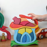 A child playing with the Glückskäfer Mushroom House wooden stacking toy. 