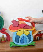 A child playing with the Glückskäfer Mushroom House wooden stacking toy. 
