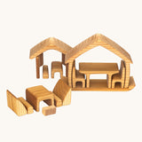 The Gluckskafer Natural All-In House wooden toy shown with all the pieces separated and placed to form two houses and a separate dining area.