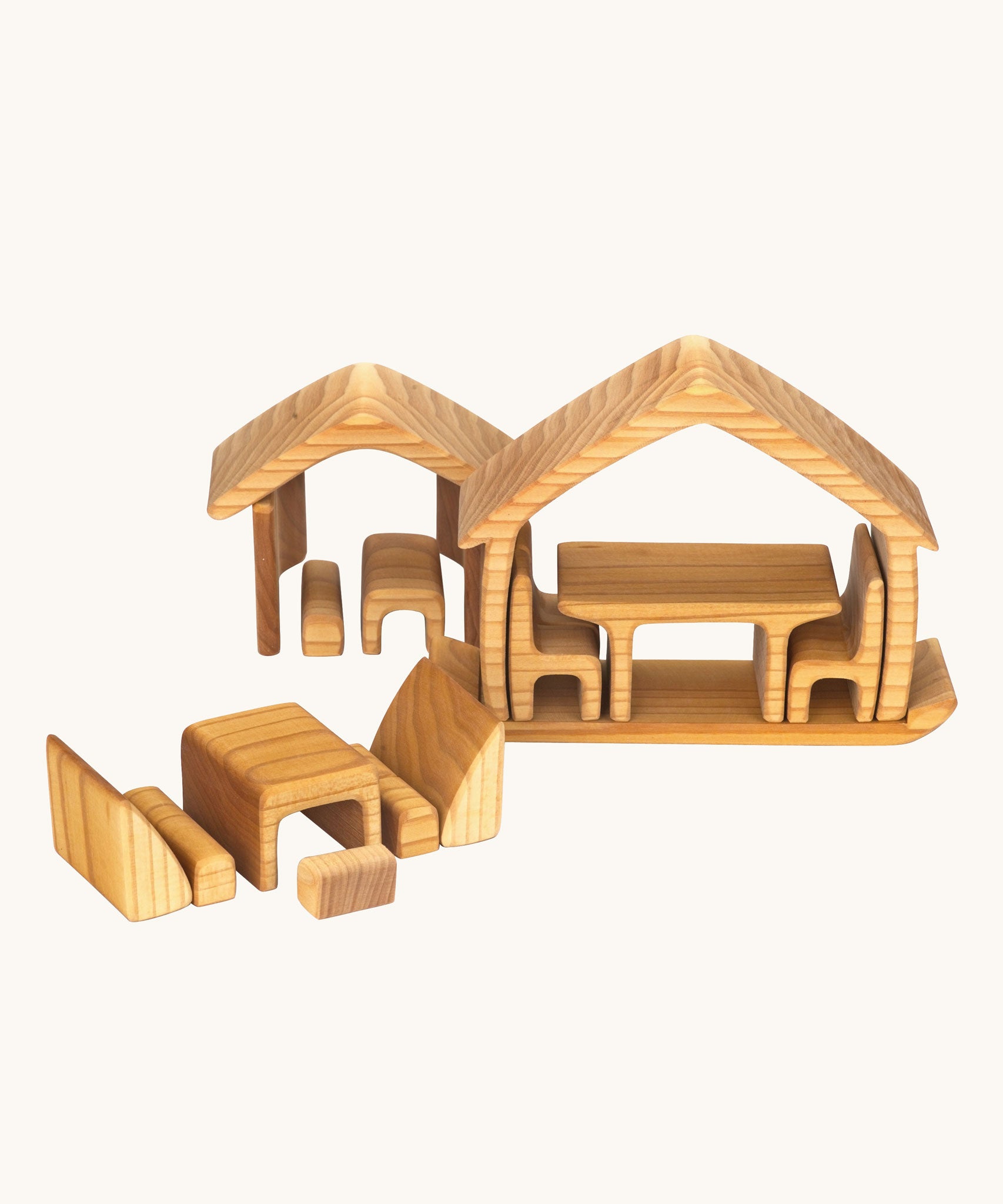 The Gluckskafer Natural All-In House wooden toy shown with all the pieces separated and placed to form two houses and a separate dining area.