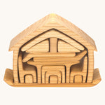 The Gluckskafer Natural All-In House wooden toy shown with all the pieces neatly stacked on it's base piece.