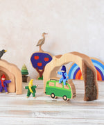 The largest piece from the Glückskäfer Natural Grotto hown in a small world play set us used as a tunnel. A Magic Wood Felt elf can be seen sitting on a Lanka Kade Lola campervan in front of the grotto piece.