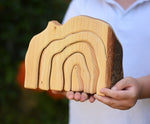 A close up of the Glückskäfer Natural Grotto shown in a child's hands.