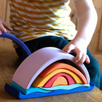 Glückskäfer wooden Purple Sunset Set Toy. A child's hand can be seen placing pieces on the stack. 