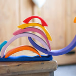 The pieces from the Glückskäfer wooden Purple Sunset Set Toy stacked in the shape of a snail. 
