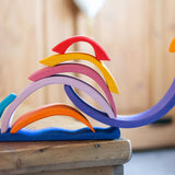The pieces from the Glückskäfer wooden Purple Sunset Set Toy stacked in the shape of a snail. 