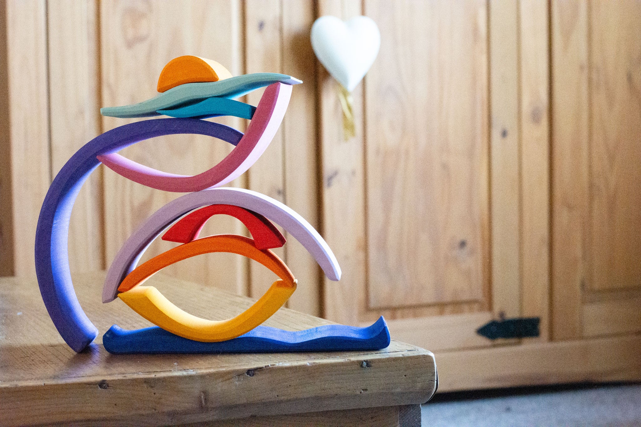 Glückskäfer wooden Purple Sunset Set Toy. The pieces have been stacked and balanced on top of each other. 