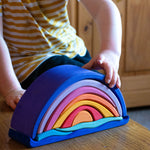Glückskäfer wooden Purple Sunset Set Toy. A child's hand can be seen placing pieces on the stack. 