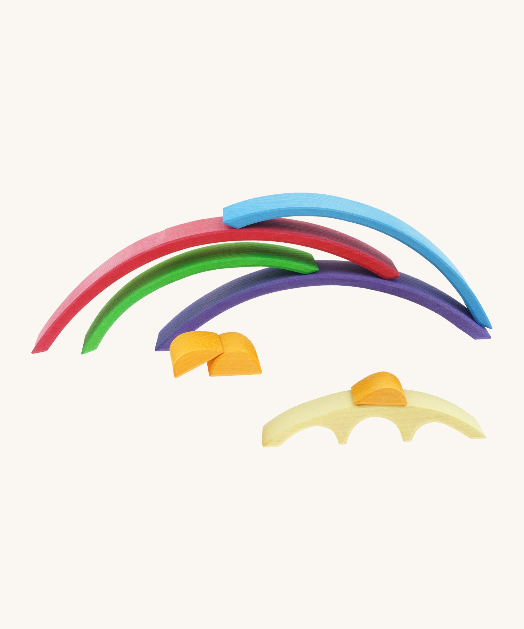 A Gluckskafer rainbow bridge  toy with all of the pieces stacked on top of each other with a orange block sitting on top of the smallest yellow arch piece.