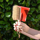 Glückskäfer red metal dust pan and dust brush in a child's hands.
