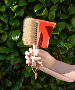 Glückskäfer red metal dust pan and dust brush in a child's hands.