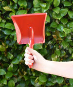 Glückskäfer red metal dust pan help up in a child's hand.