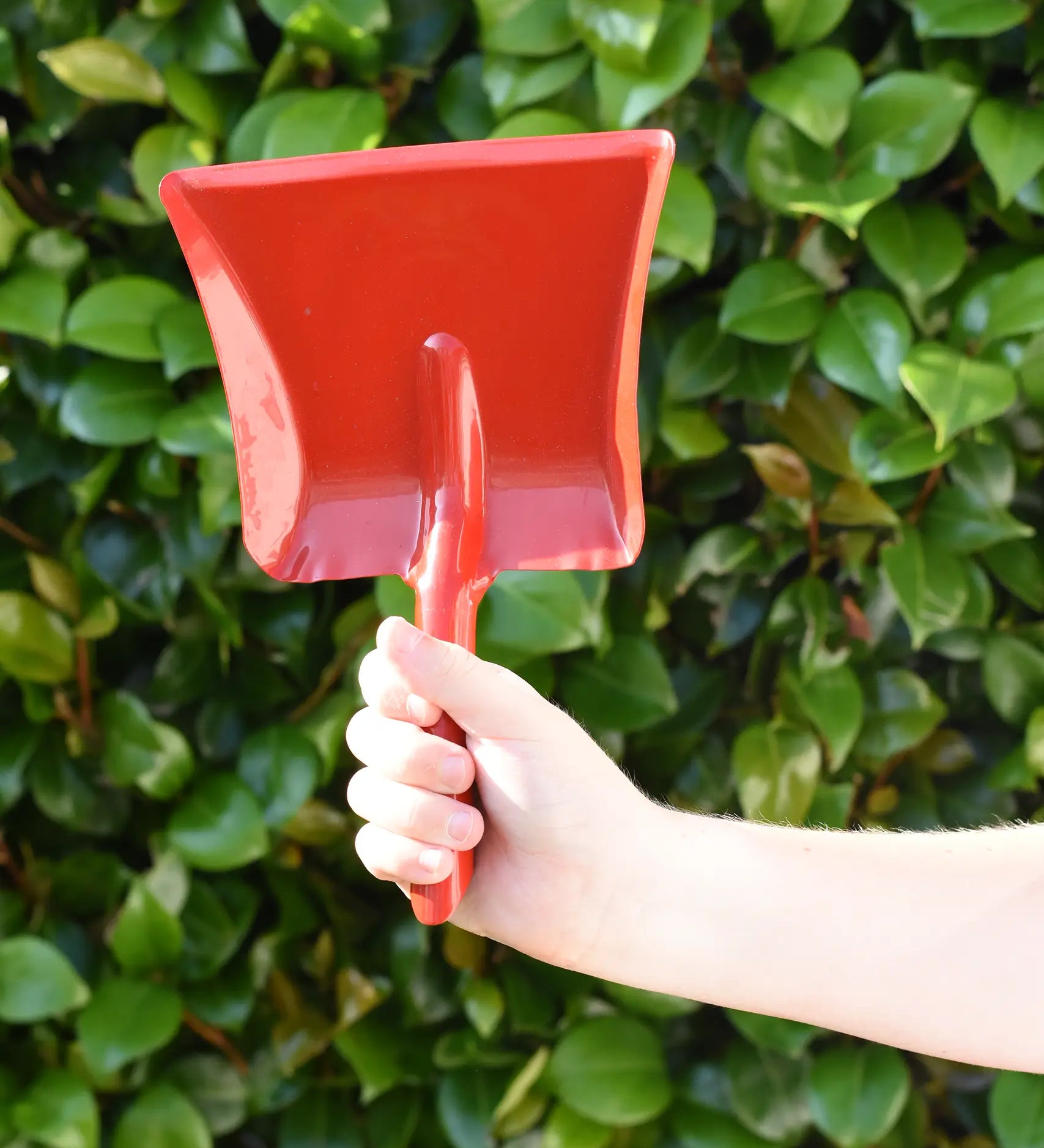 Glückskäfer red metal dust pan help up in a child's hand.
