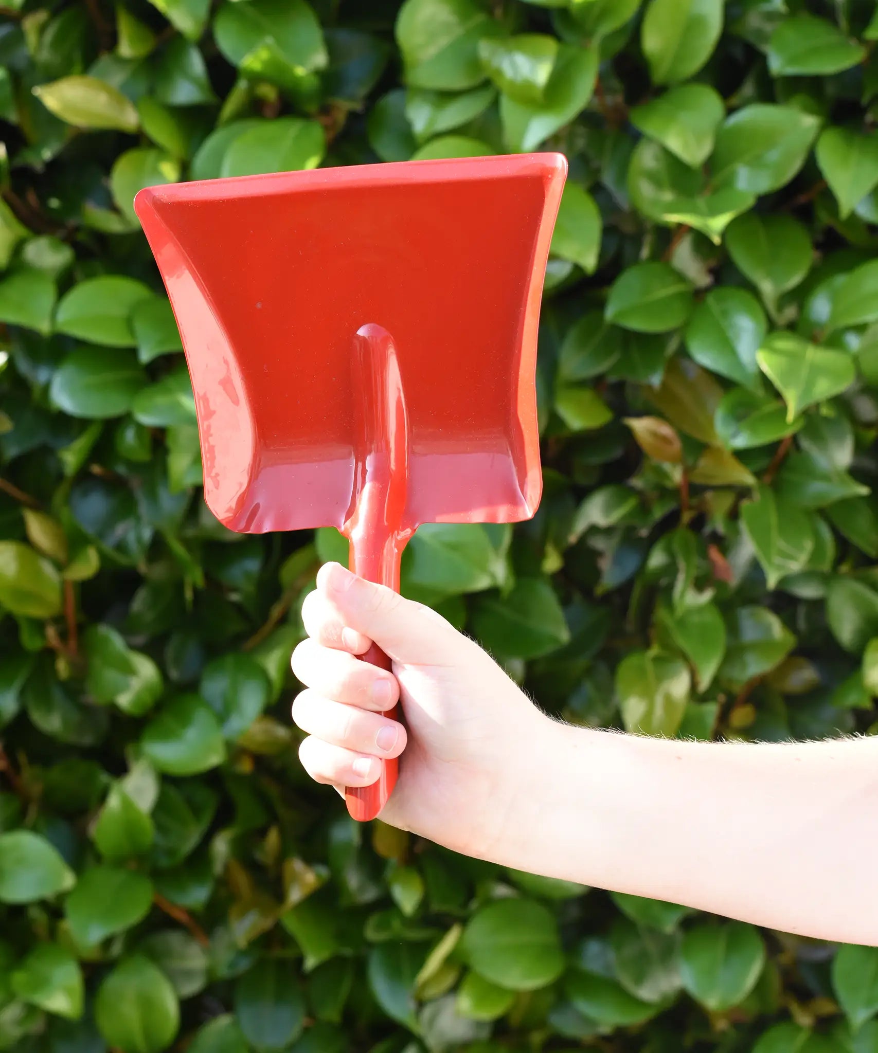 Glückskäfer red metal dust pan help up in a child's hand.