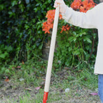 A child holding up a Glückskäfer 60cm Metal Red Hoe. 