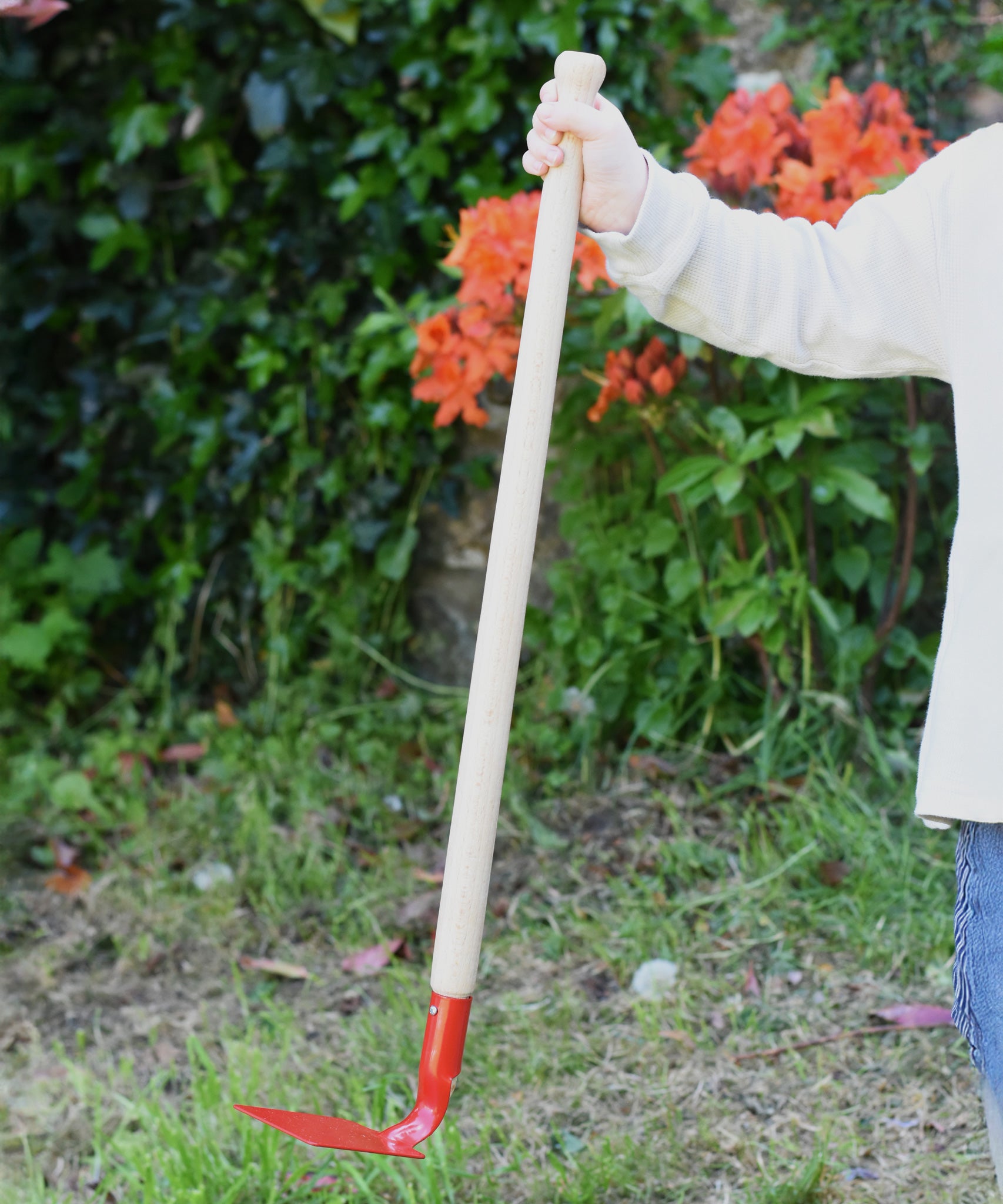 A child holding up a Glückskäfer 60cm Metal Red Hoe. 