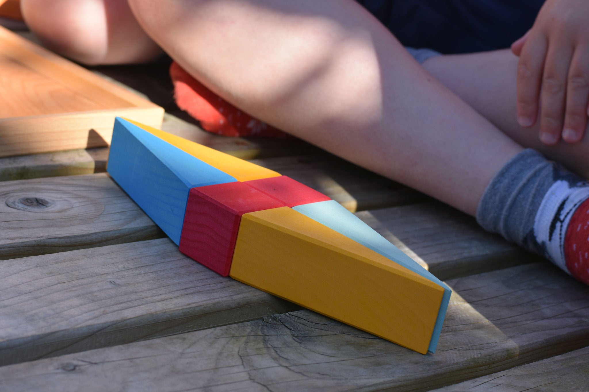 A close up of a kite shaped creation created using wooden toy blocks from the Glückskäfer 20-Piece Small Toscana Blocks Set. 