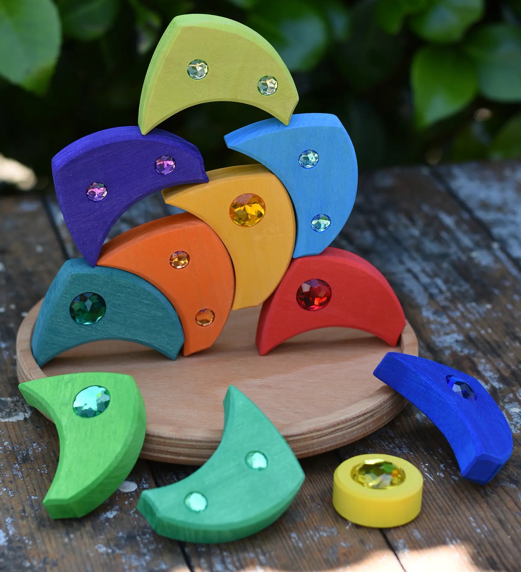 Glückskäfer sparkling swirl wooden spinning toy, pieces stacked up on the wooden circle base.