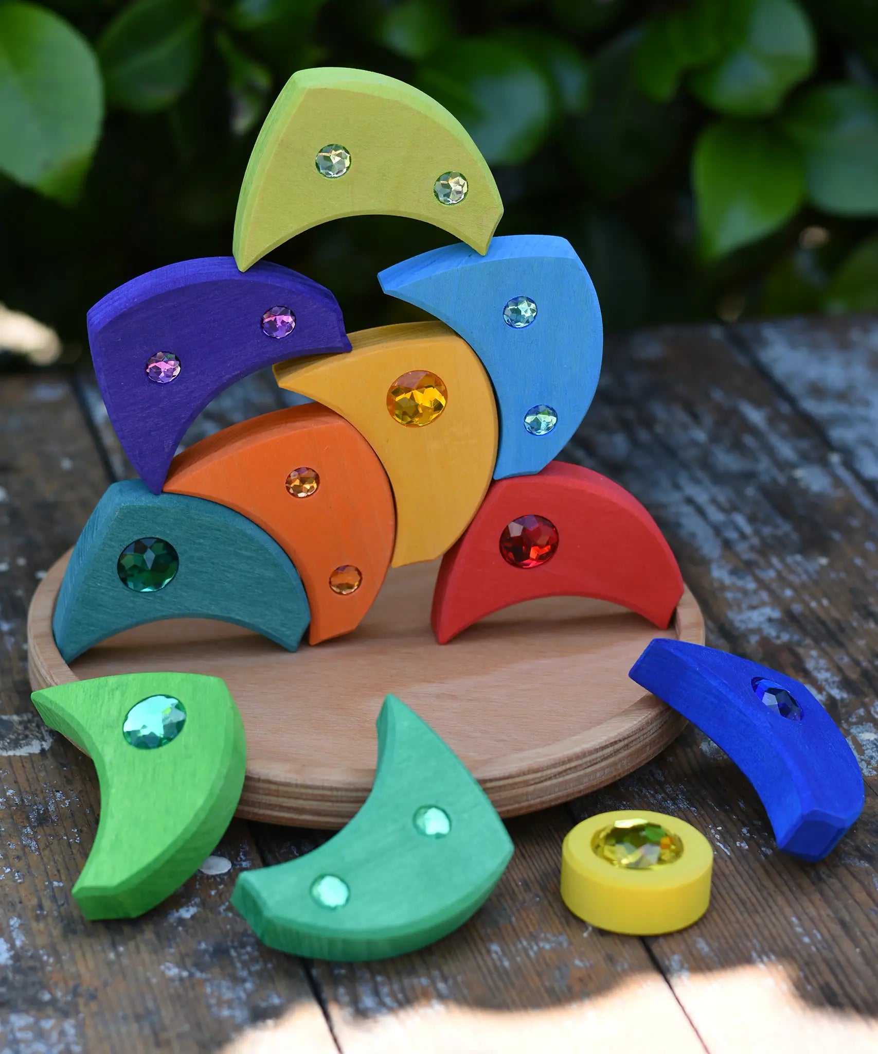 Glückskäfer sparkling swirl wooden spinning toy, pieces stacked up on the wooden circle base.