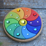 Glückskäfer sparkling swirl wooden spinning toy placed on a wooden surface. 