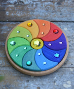 Glückskäfer sparkling swirl wooden spinning toy placed on a wooden surface. 