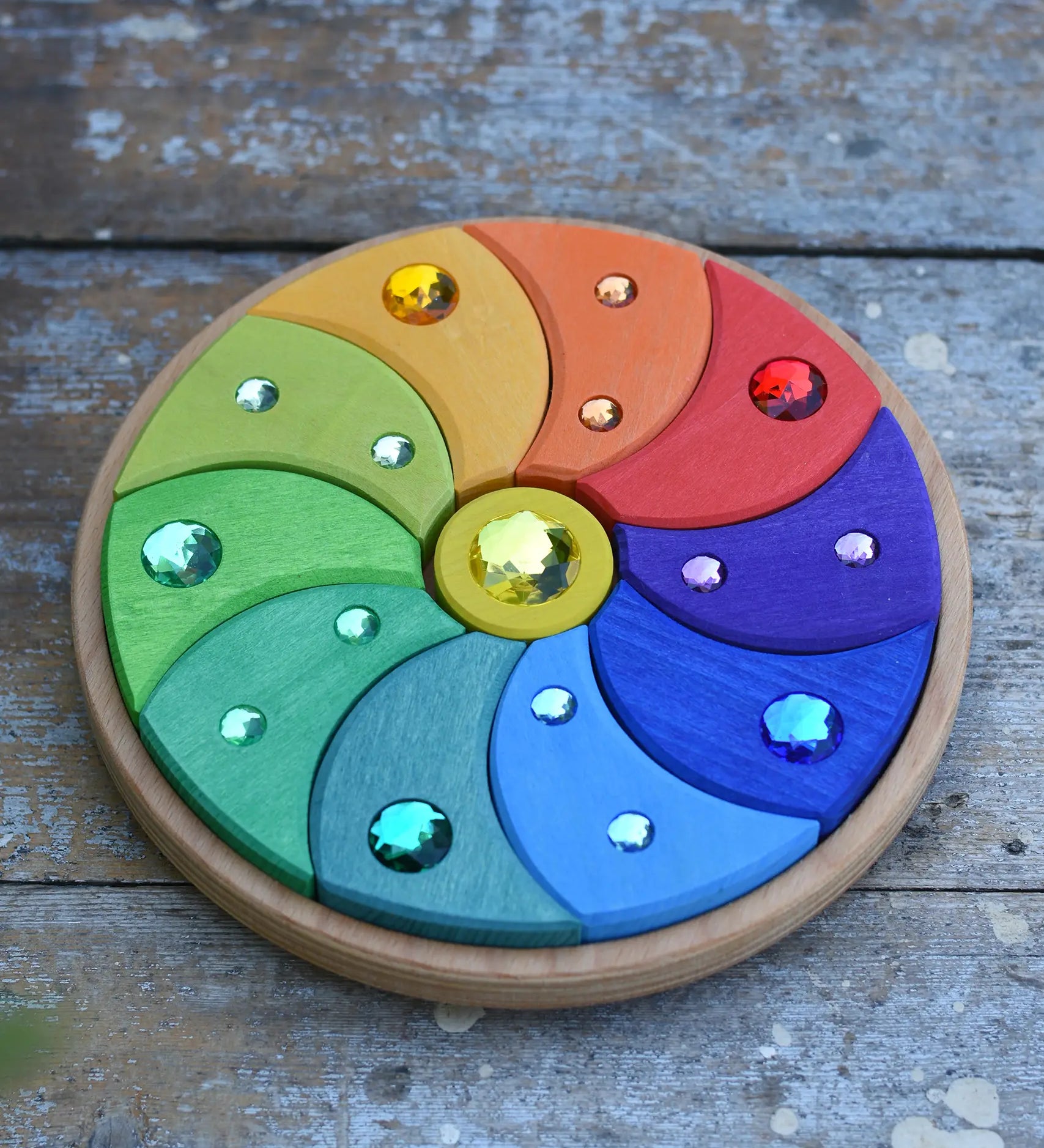 Glückskäfer sparkling swirl wooden spinning toy placed on a wooden surface. 