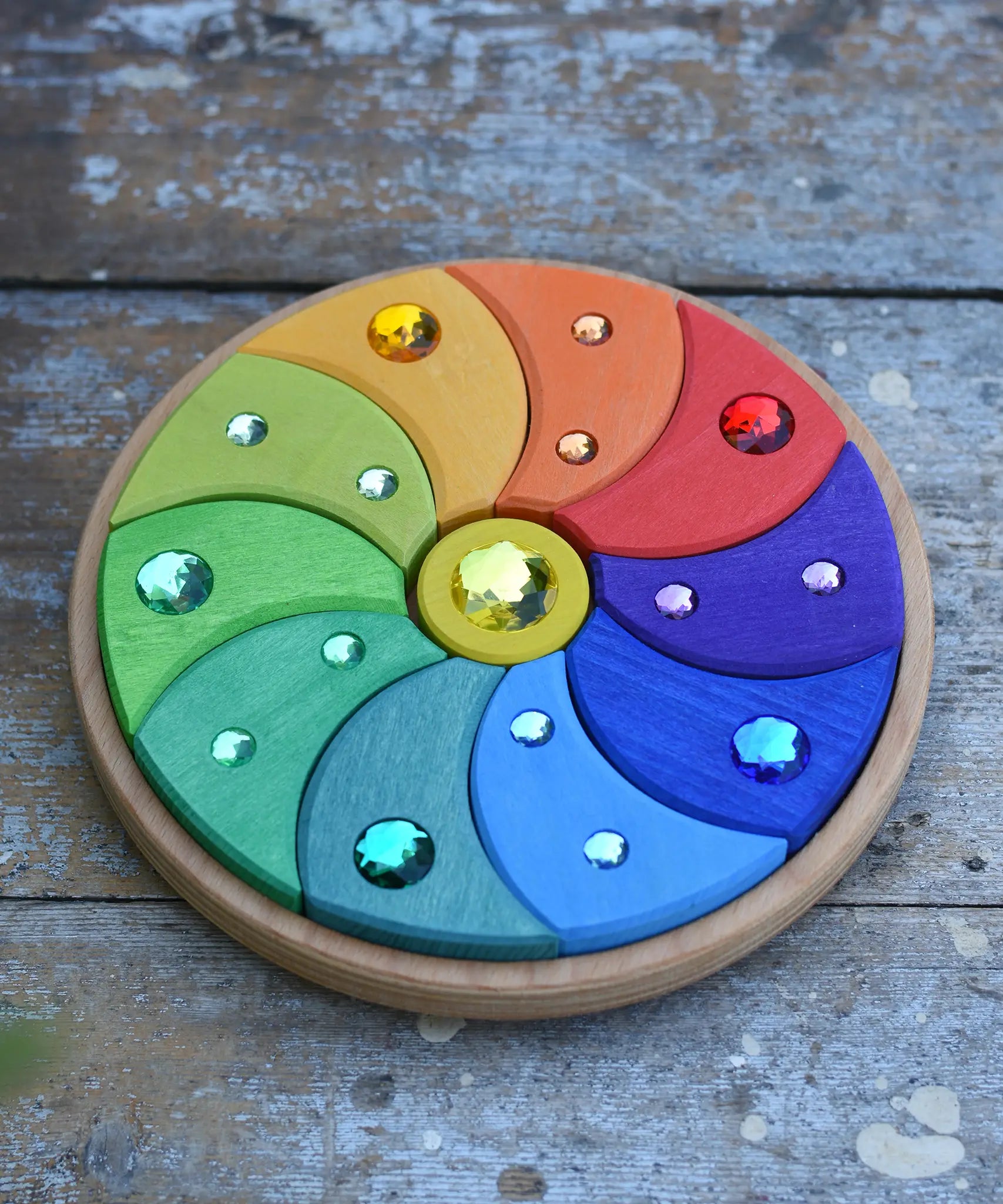 Glückskäfer sparkling swirl wooden spinning toy placed on a wooden surface. 