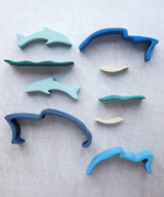 The pieces from the Gluckskafer Stacking Dolphin toy laid out. 