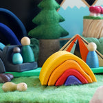 Close up of the Gluckskafer wooden bonfire on a green felt base surrounded by Grapat nins and lanka kade dan y ser toys in a campfire scene