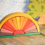 The Glückskäfer Yellow Sunray Arch placed on a wooden surface with a Holztiger oak tree figure in the background. 