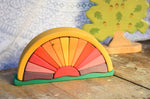 The Glückskäfer Yellow Sunray Arch placed on a wooden surface with a Holztiger oak tree figure in the background. 