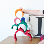 A child stacking pieces of the Glückskäfer Gable House wooden toy on top of each other 