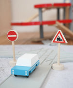 Gluckskafer miniature railway crossing wooden traffic sign next to a playroad and Candylab car on top and parking garage in the background
