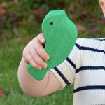 A close up of the green bird from the Glückskäfer Bird Stacker in a child's hand. 