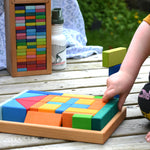 A child's hand taking pieces out of the tray from the Glückskäfer 29-Piece House Blocks set.