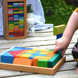 A child's hand taking pieces out of the tray from the Glückskäfer 29-Piece House Blocks set.