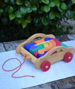 Gluckskafer carriage wooden toy block set. A natural wood pull along car with 17 colourful blocks.