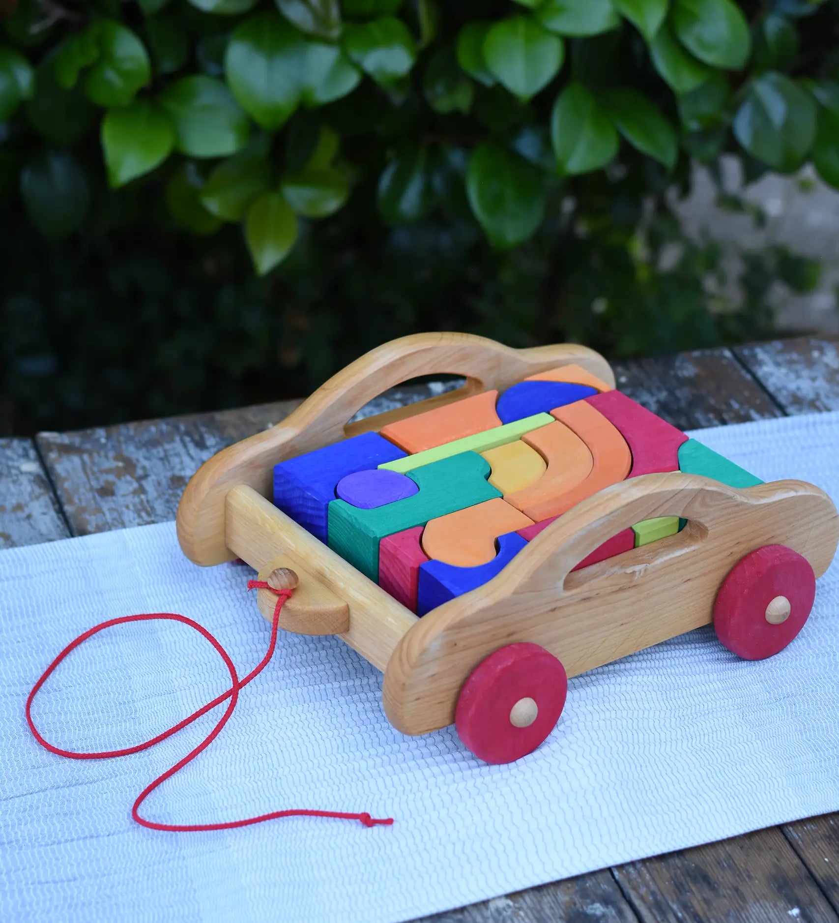 Gluckskafer carriage wooden toy block set. A natural wood pull along car with 17 colourful blocks.