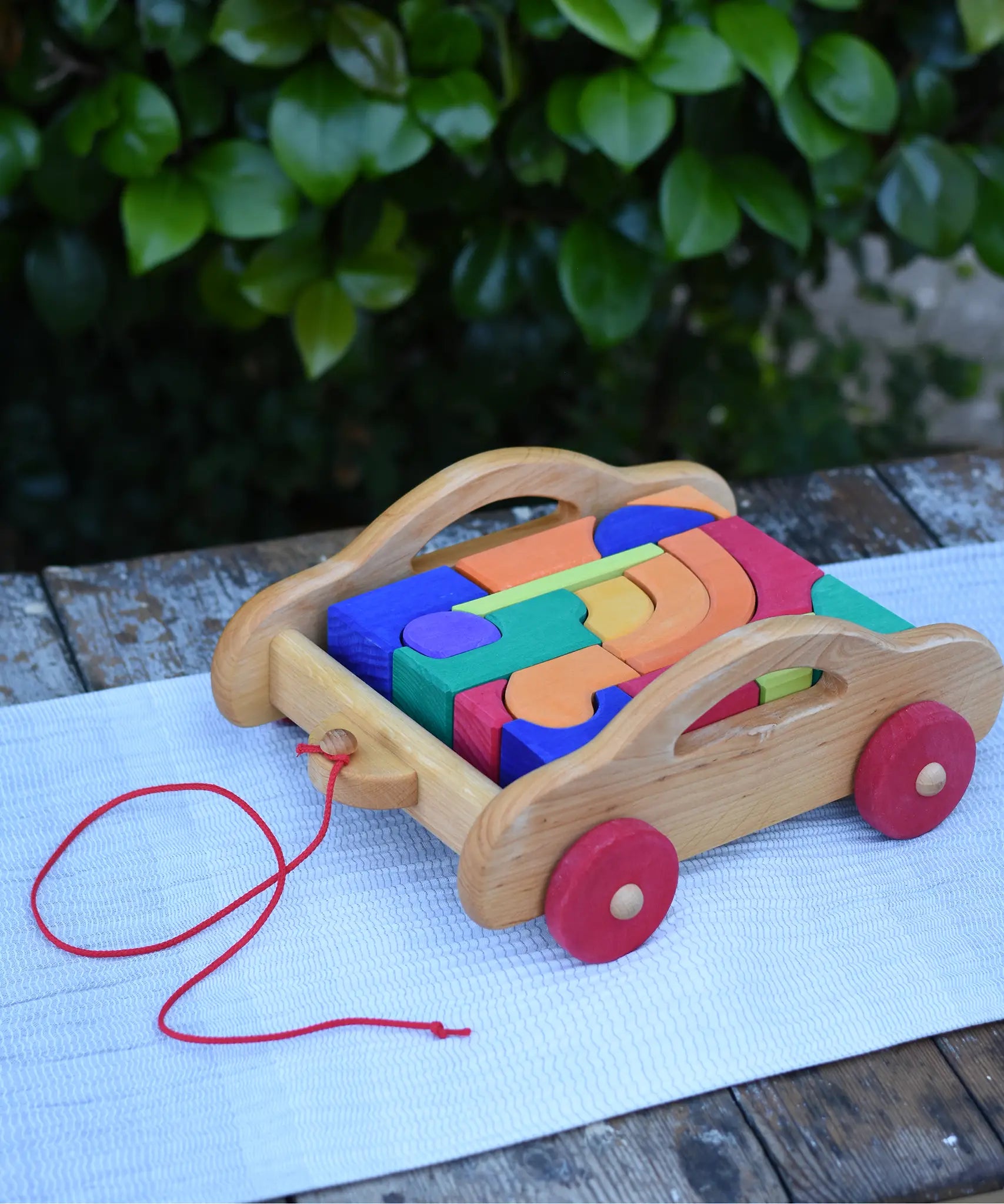 Gluckskafer carriage wooden toy block set. A natural wood pull along car with 17 colourful blocks.