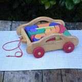 Gluckskafer carriage wooden toy block set. A natural wood pull along car with 17 colourful blocks.