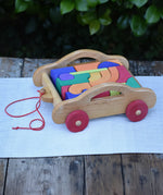 Gluckskafer carriage wooden toy block set. A natural wood pull along car with 17 colourful blocks.