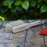 Glückskäfer wooden dust brush with natural horse hair bristles placed on a wooden surface.