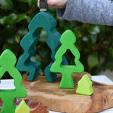 Child playing with the Glückskäfer 6-Piece Fir Tree wooden tree stacking toy holding an Ostheimer blackbird in his hans.