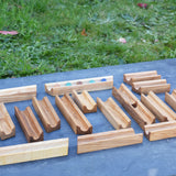 The pieces from the Glückskäfer 23 Piece Wooden Marble Track laid out onto a slate surface outdoors. 