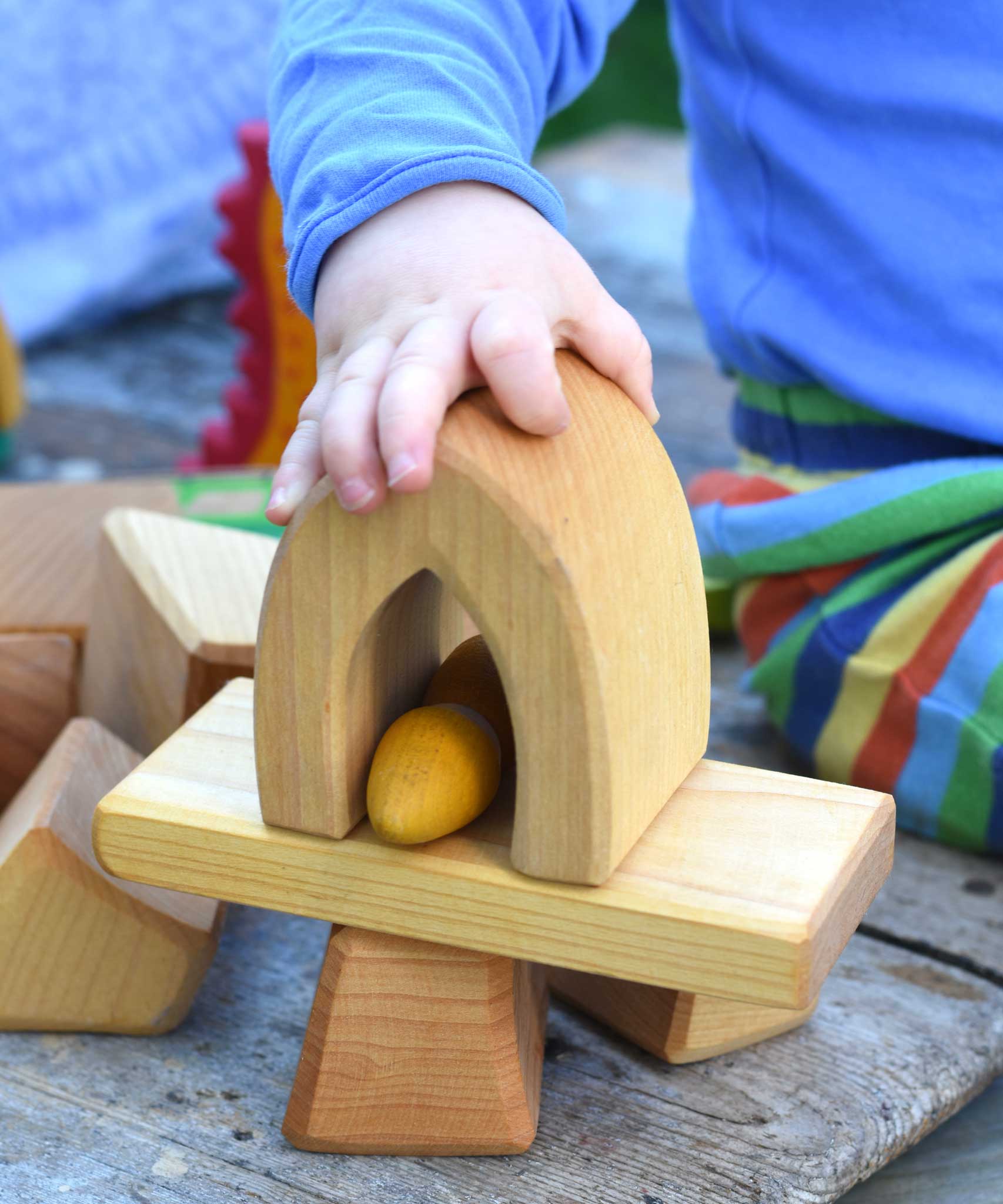 A child playing with the blocks from the Glückskäfer 17 Large Natural Blocks Set.