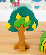 Glückskäfer Wooden Pear Tree Stacking Puzzle Toy placed on a wooden floor. 