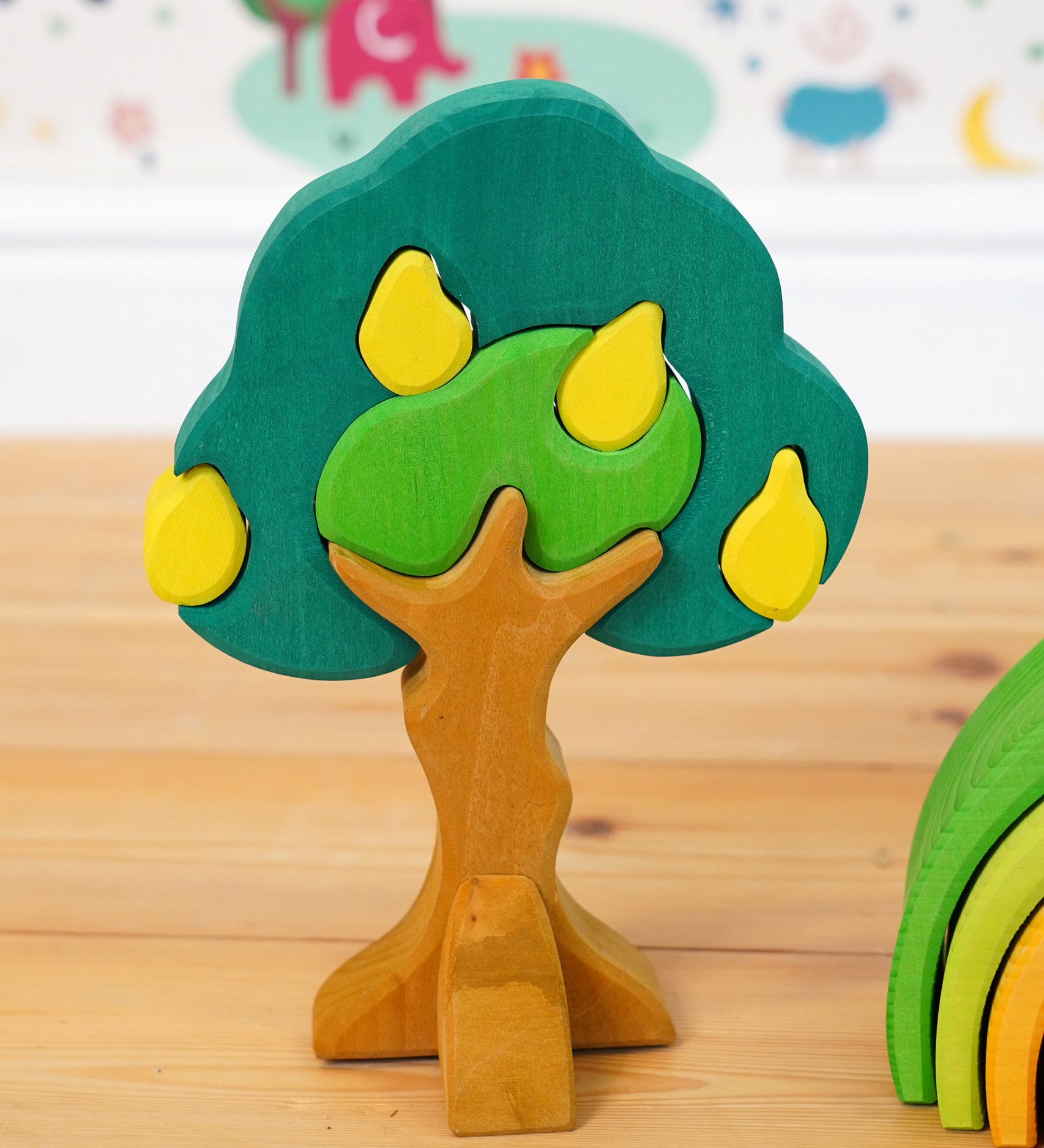 Glückskäfer Wooden Pear Tree Stacking Puzzle Toy placed on a wooden floor. 