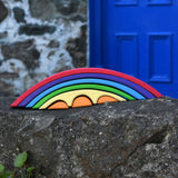 The Gluckskafer Rainbow Bridge placed on an uneven stone wall outdoors. 
