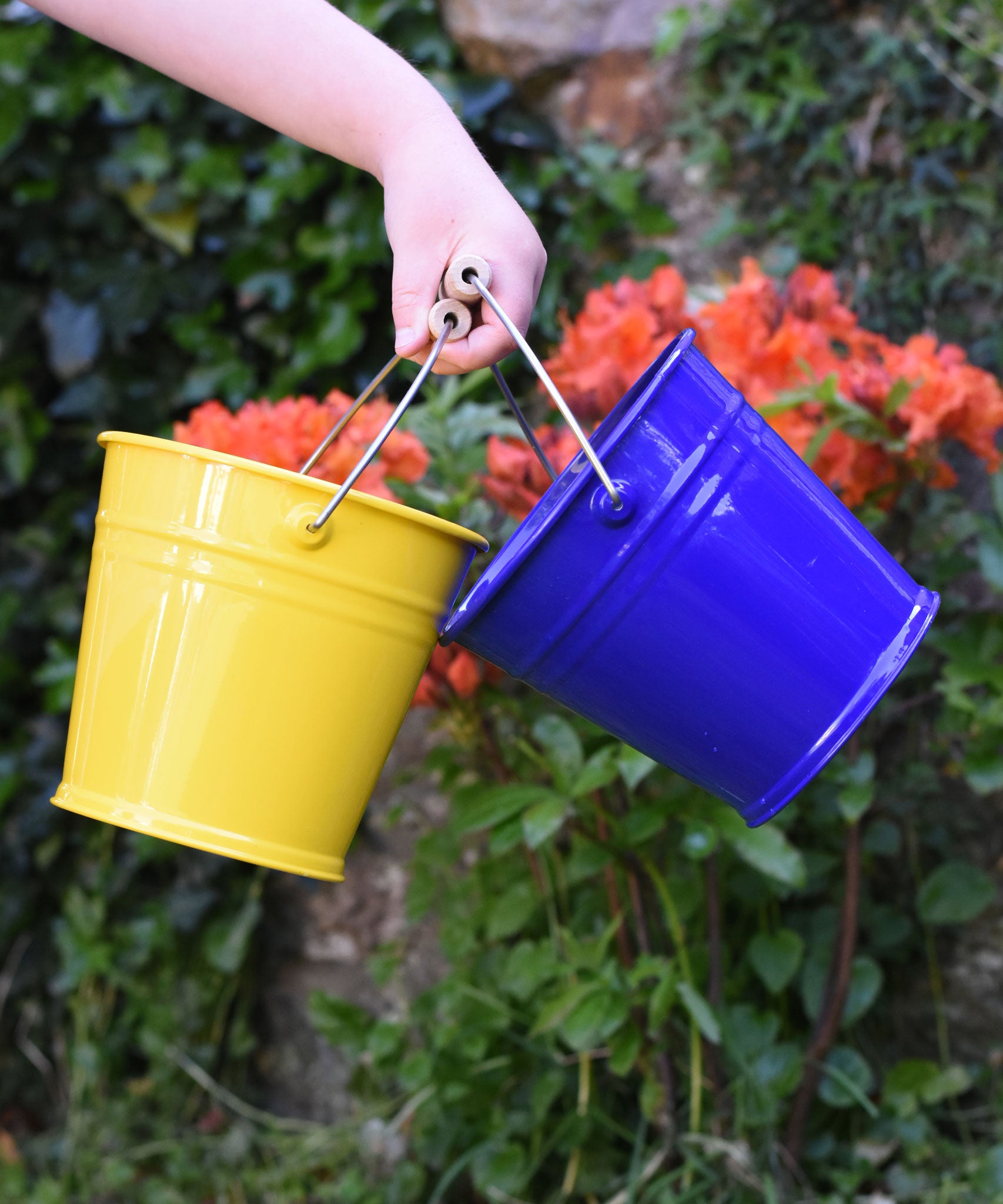 Glückskäfer Yellow and blue Metal Buckets in a child's hand