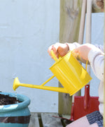 A child using the Glückskäfer Children's 1L yellow Metal Watering Can.